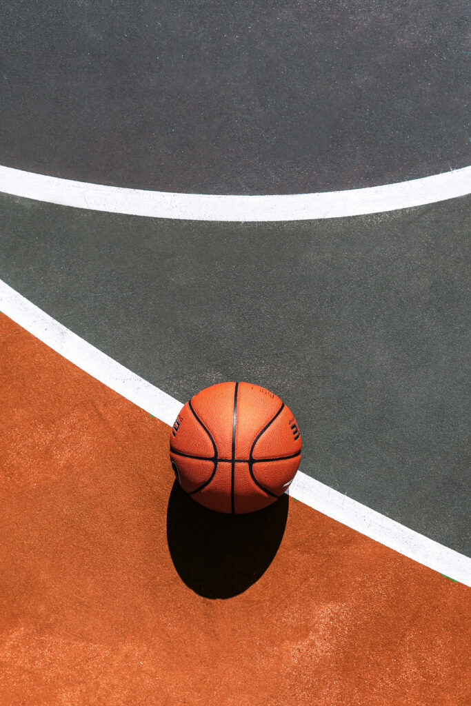 Vibrant Basketball Wallpaper: Lone Ball on Colorful Court Background