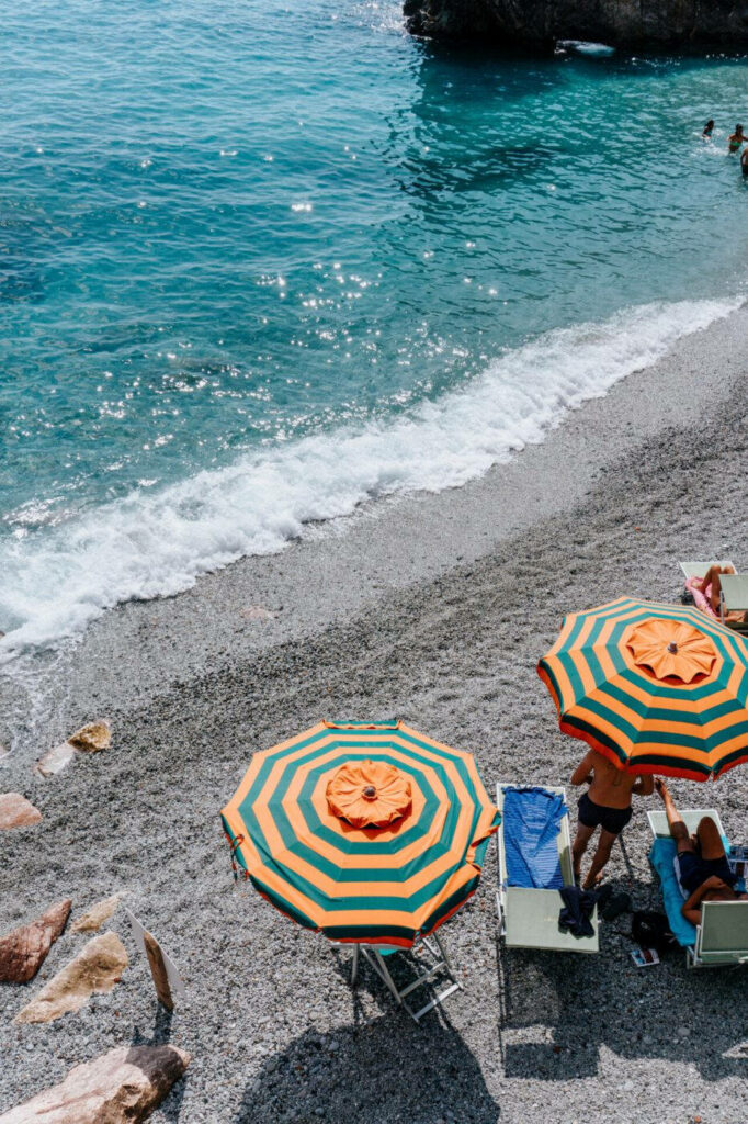 Vibrant Beach Vibes: Colorful Umbrellas & Turquoise Water Wallpaper