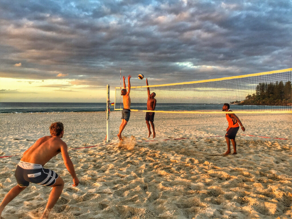 Vibrant Beach Volleyball Match at Sunset - Serene Ocean Wallpaper