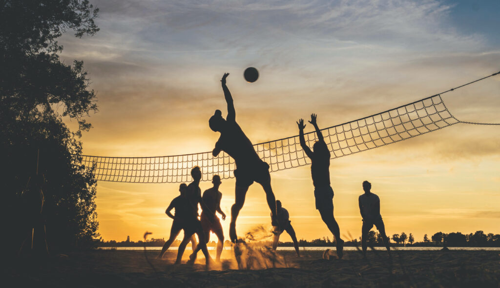 Dynamic Beach Volleyball Wallpaper: Fun & Dedication at Sunset