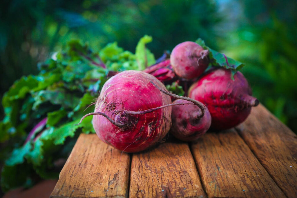 Vibrant Beetroot Wallpaper: Rustic Wooden Board with Leafy Greens