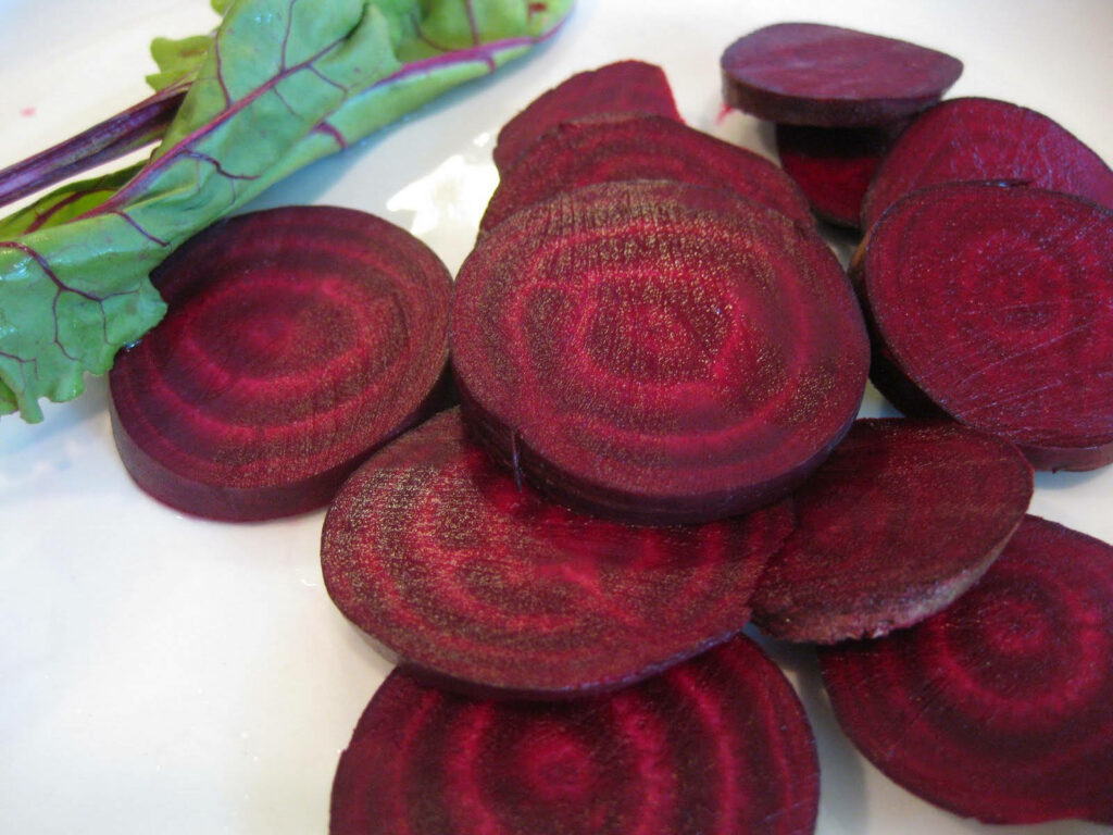 Freshly Sliced Beetroot Wallpaper: Vibrant Red & Green Background