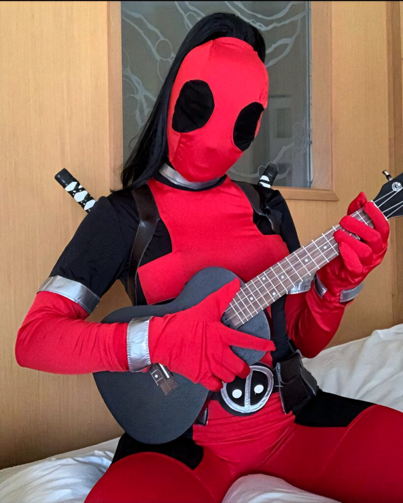 Vibrant Bella Poarch Deadpool Cosplay Wallpaper with Humorous Ukulele