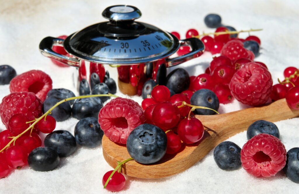 Vibrant Berry Wallpaper Background with Wooden Spoon & Timer
