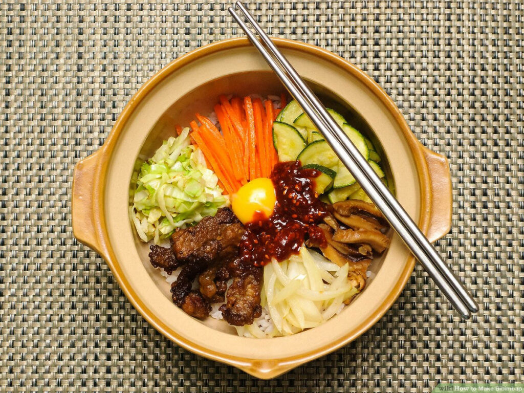 Vibrant Bibimbap Wallpaper: Sizzling Hot Pot with Colorful Veggies