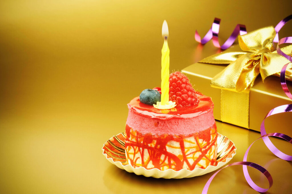 Festive Birthday Cake with Fruit & Gift on Luxurious Gold Background Wallpaper