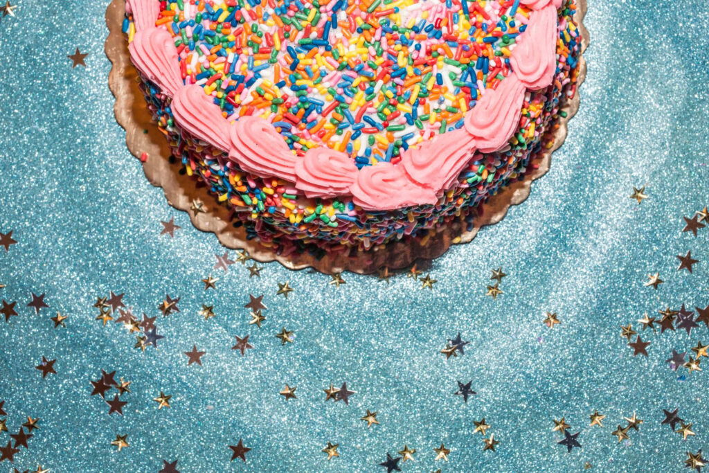 Festive Birthday Cake Wallpaper with Sprinkles and Sparkling Background