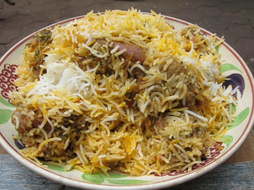 Vibrant biryani with aromatic basmati rice tender meat and rich spices served on a plate Wallpaper