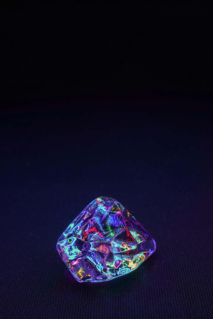 Vibrant crystal gemstone with bismuth surface glowing multicolored reflections dark background Wallpaper