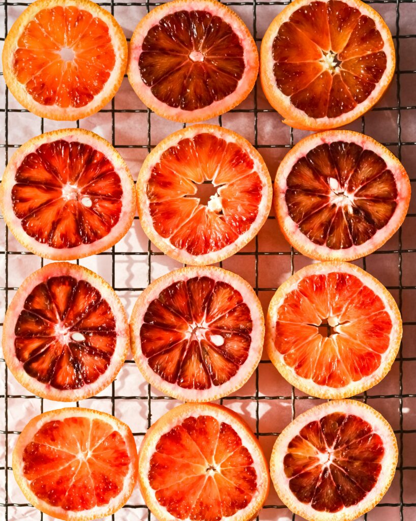 Vibrant Blood Orange Wallpaper: Fresh Slices on Mesh Grid Background