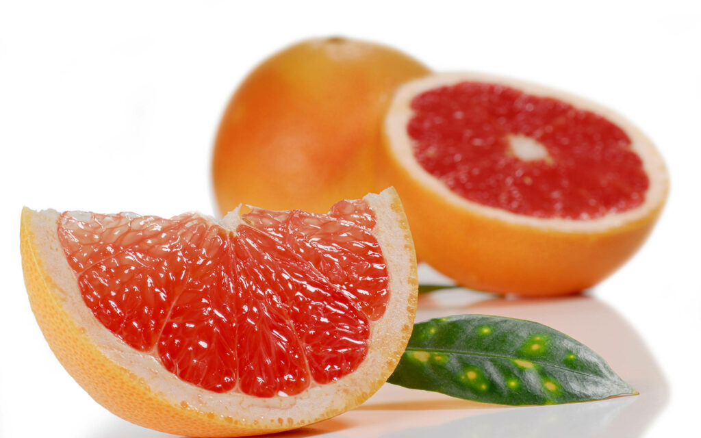 Vibrant fresh blood oranges with juicy red flesh on a bright modern clean wallpaper background