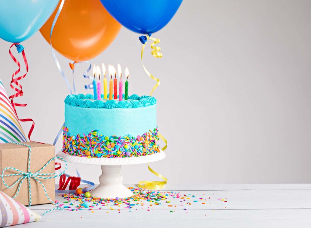 Vibrant Blue Birthday Cake with Candles, Balloons & Gifts Celebration Wallpaper