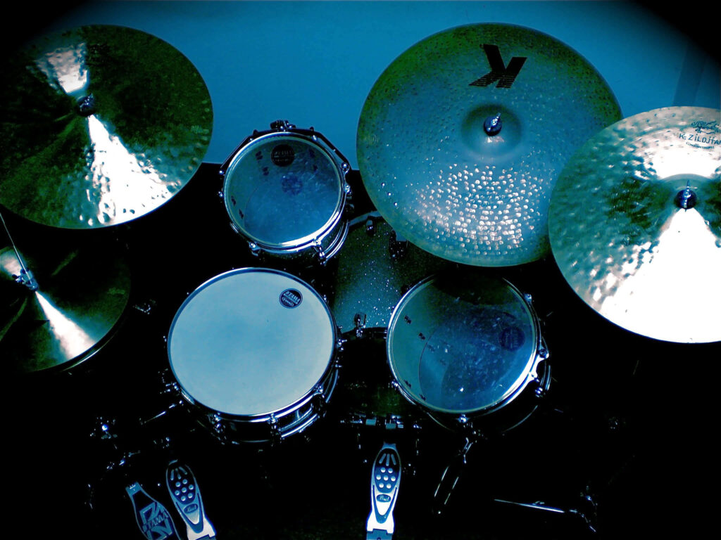 Vibrant drum set wallpaper with metallic cymbals and blue lighting showcasing percussion detail