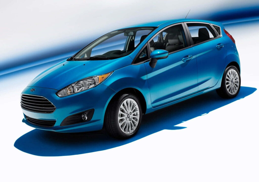 Vibrant blue Ford Fiesta car with modern blue and white backdrop showcasing stylish design Wallpaper