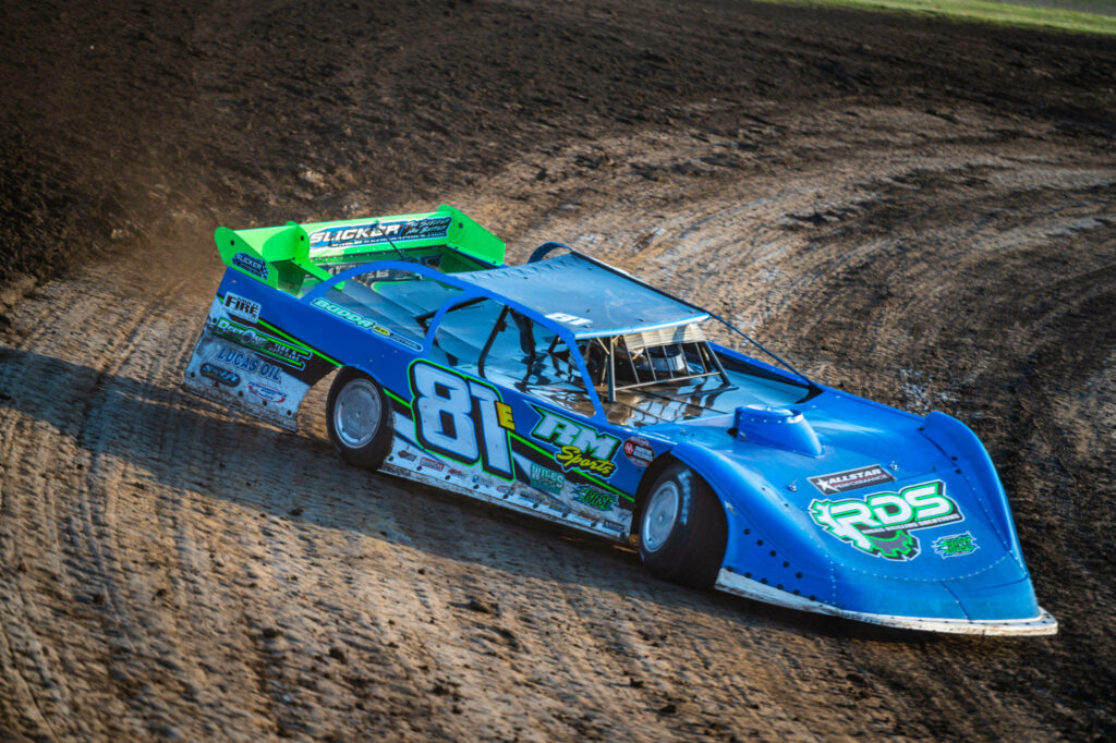 Blue and green dirt car number 81 kicking dust on rugged track sharp turn dirt racing wallpaper