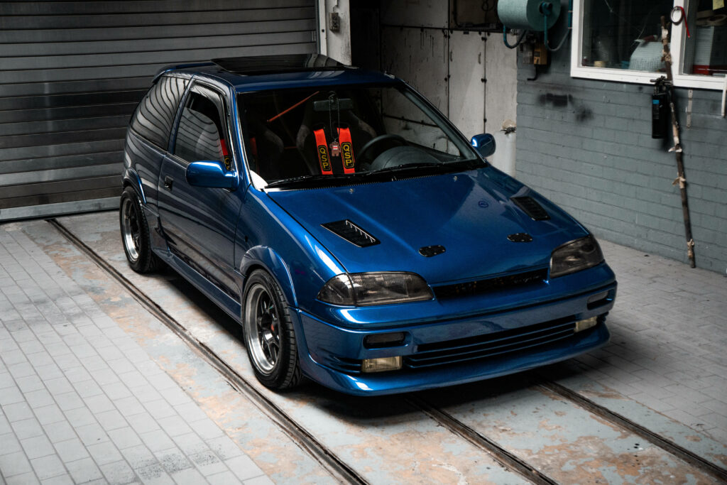 Vibrant Blue Modified JDM Car Wallpaper in Urban Garage