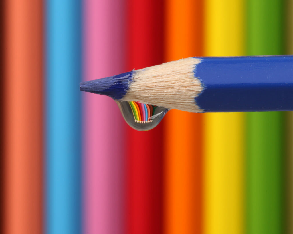 Blue Pencil with Water Droplet Against Vibrant Pencil Wallpaper