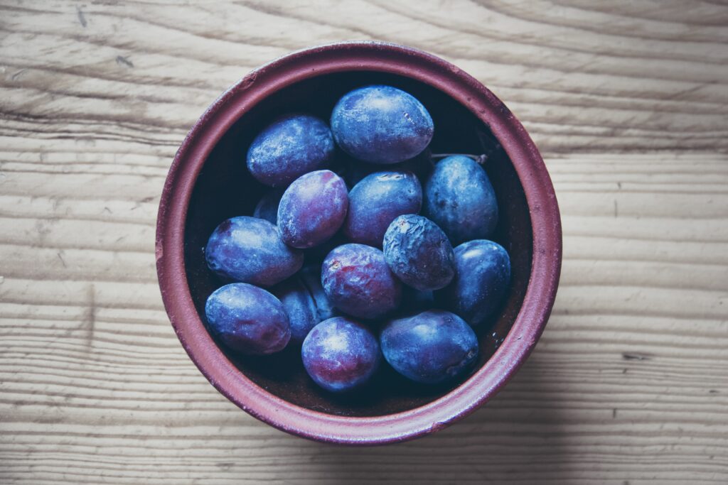Rustic Wooden Wallpaper with Fresh Blue-Purple Plums