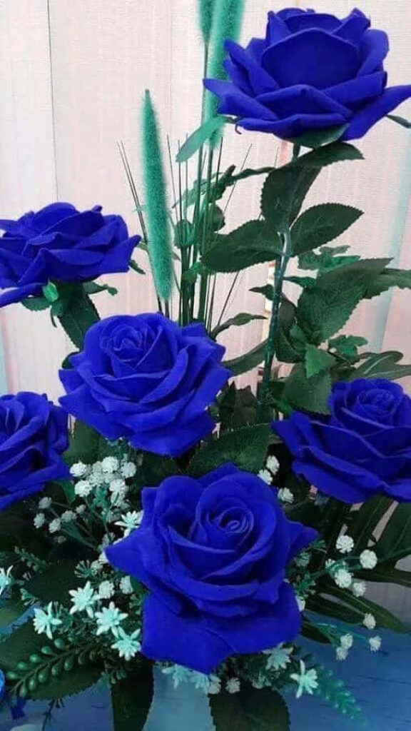 Vibrant Blue Roses Against Lush Green Leaves - Elegant Floral Background Wallpaper