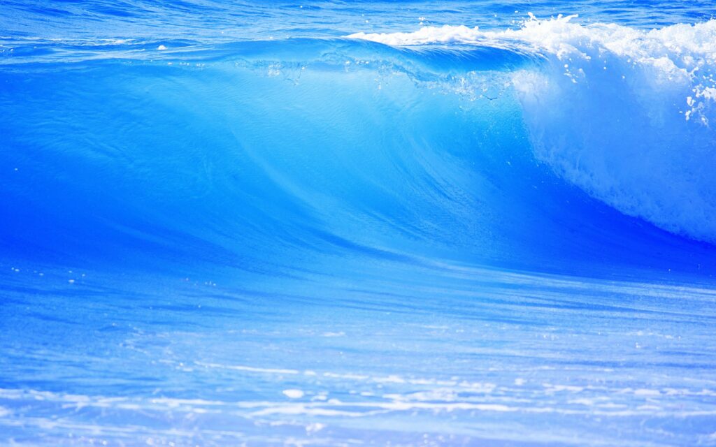Powerful blue ocean wave in motion with detailed water textures and vibrant natural energy wallpaper