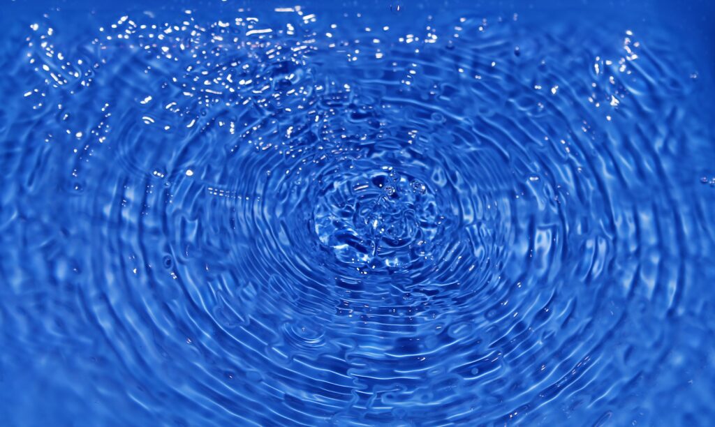 Vibrant Blue Water Wallpaper: Symmetrical Circles & Soothing Ripples