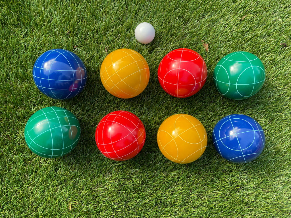 Colorful Bocce Balls Wallpaper on Lush Green Grass - Playful Background