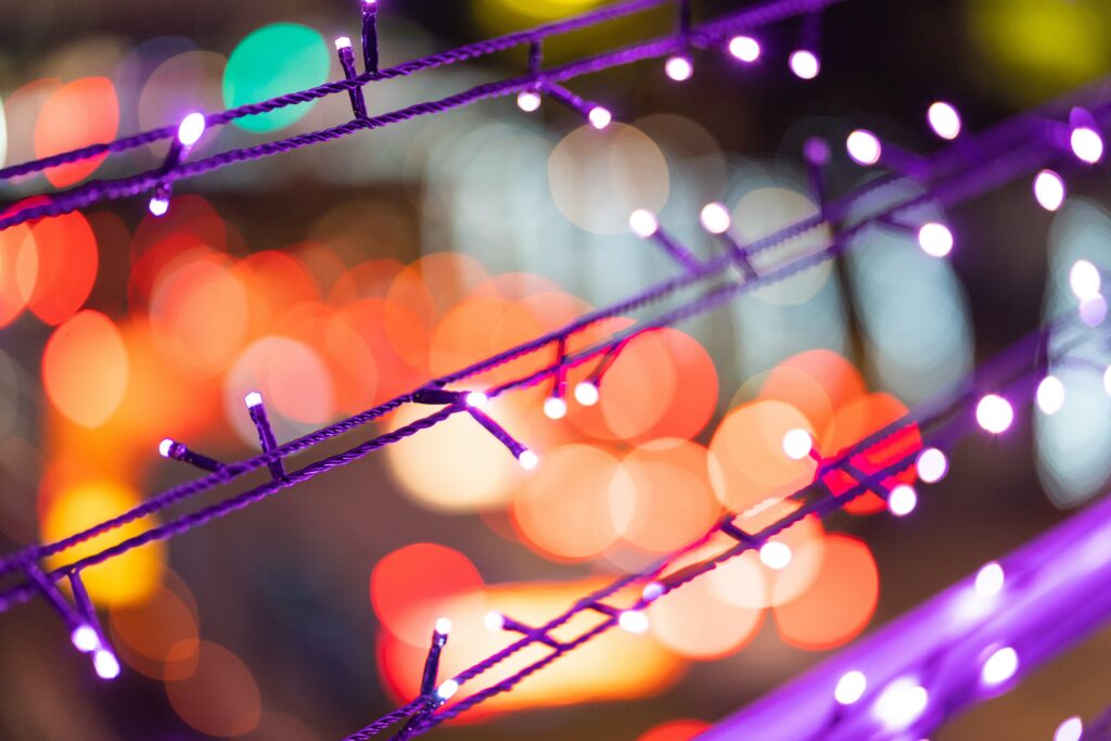 Festive Bokeh Wallpaper: Colorful Lights & Purple Garlands Glow