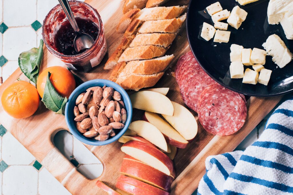 Vibrant Breakfast Spread with Almonds, Sausage, and Cheese on Wood Wallpaper