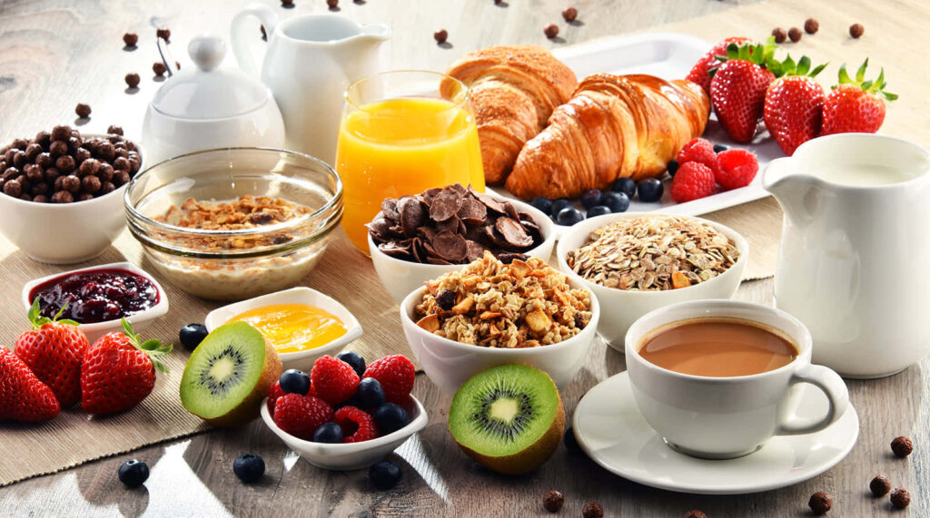 Vibrant Breakfast Spread: Fresh Fruits, Pastries, Coffee & Tea Wallpaper