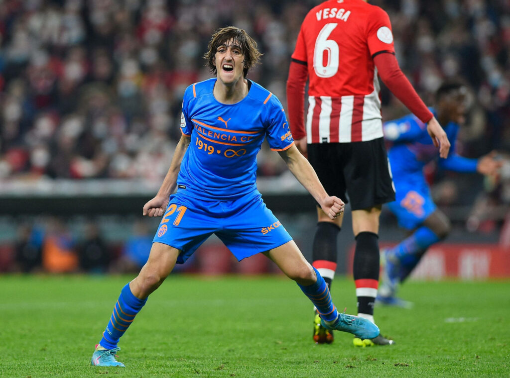 Bryan Gil celebrating in bright blue Valencia CF kit with stadium crowd vibrant football wallpaper