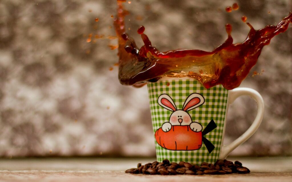 Cheerful Bunny Cup with Coffee Splash - Vibrant Wallpaper Background