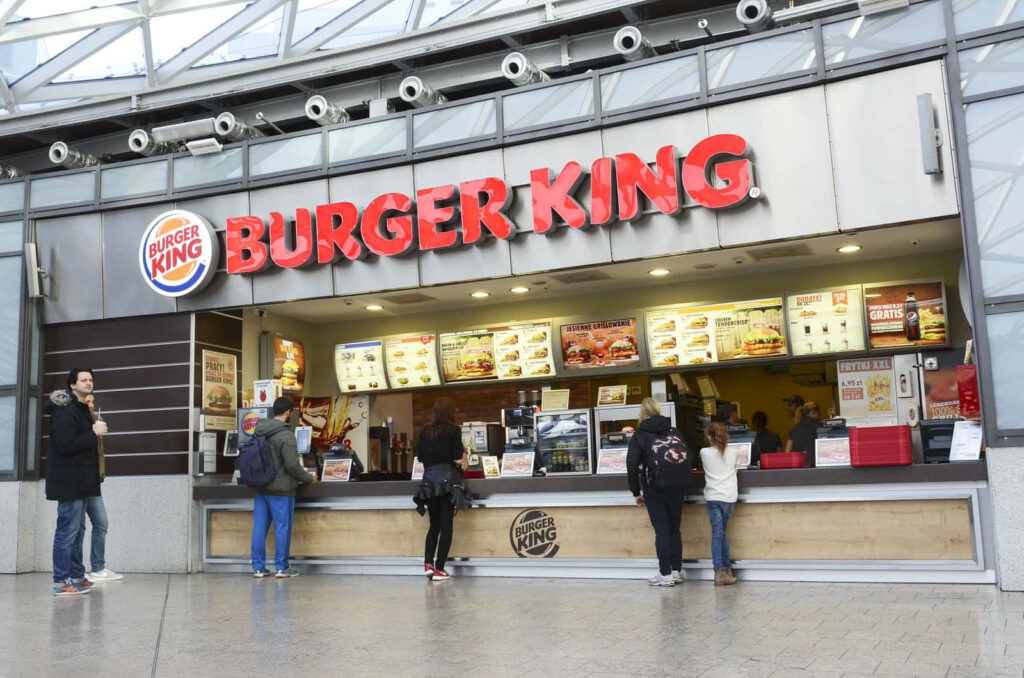 Vibrant Burger King restaurant interior with bright red logo customers ordering at modern counter Wallpaper