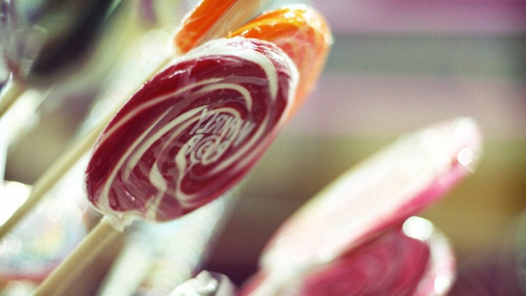 Colorful Swirled Lollipop Wallpaper: Delightful Candy Background