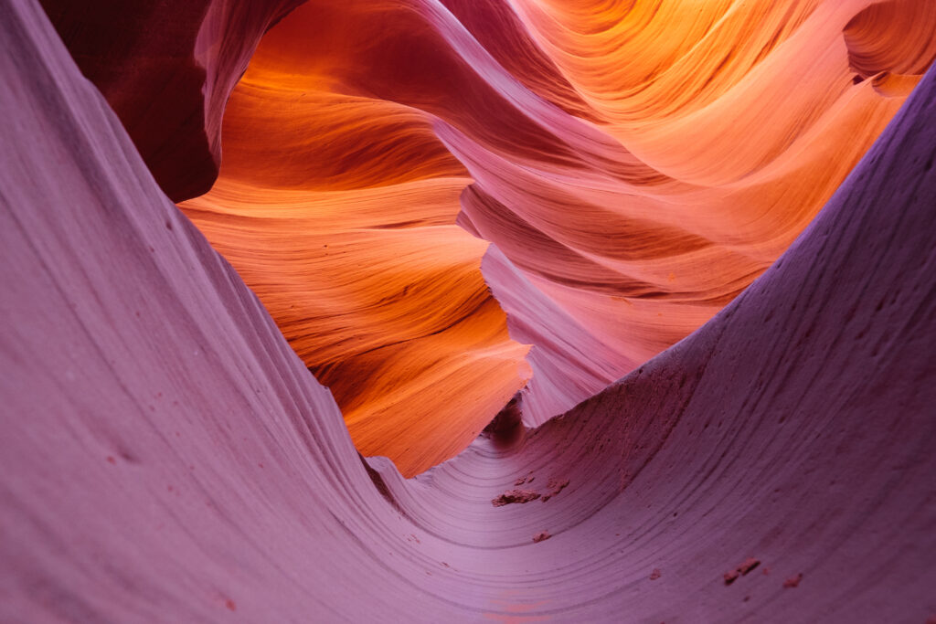 Abstract canyon wallpaper with flowing curves textured layers in vibrant orange pink and purple hues