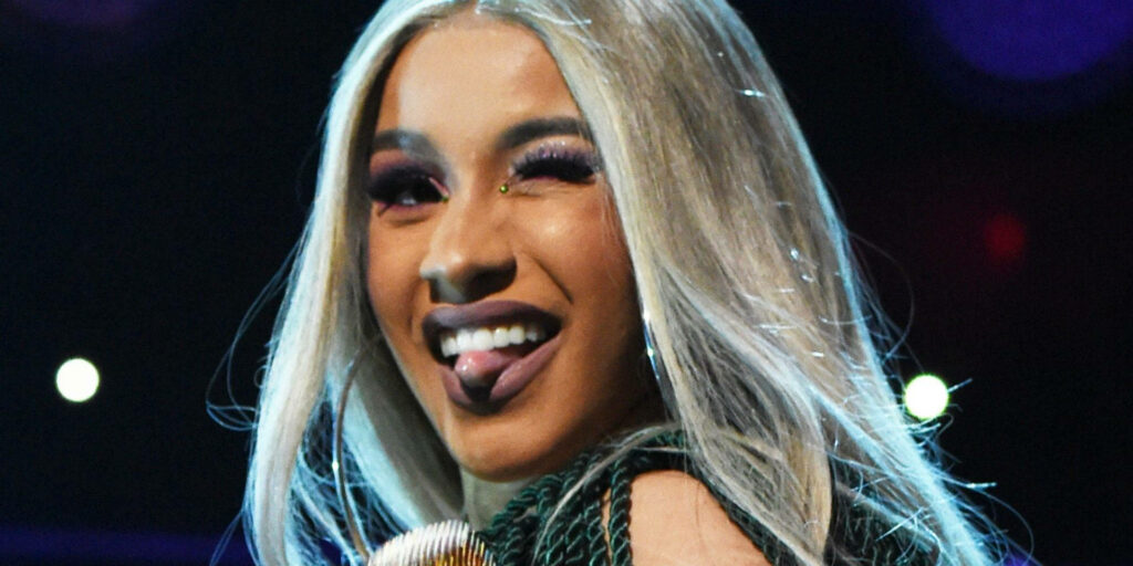 Vibrant Cardi B Wallpaper: Playful Winking and Tongue Out Background