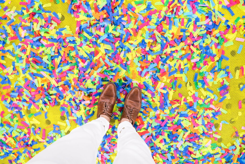 Confetti Dream: A High Definition Wallpaper featuring a Person Standing Amid Colorful Celebration