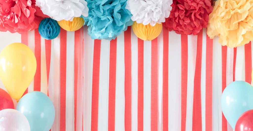 Vibrant Celebration Wallpaper: Red Stripes & Colorful Pom-Poms