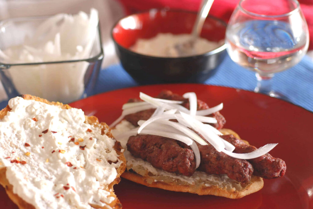 Delicious Ćevapi Sausages on Flatbread - Vibrant Wallpaper Design