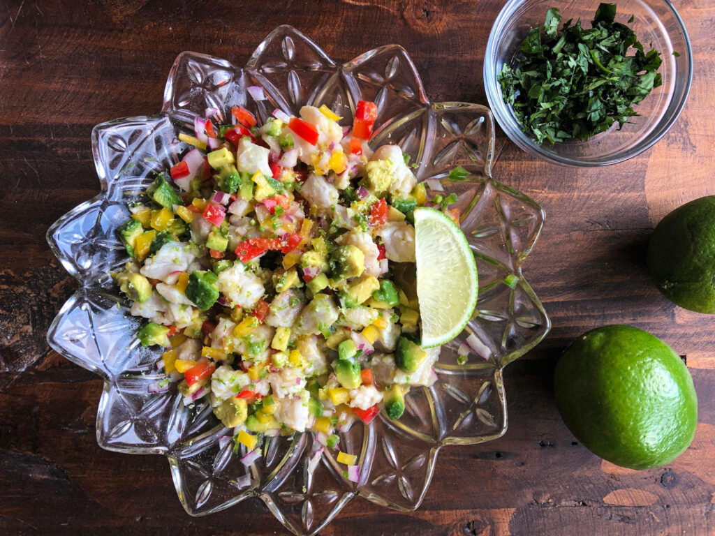 Vibrant ceviche with colorful seafood and vegetables on flower platter with fresh lime wedge Wallpaper