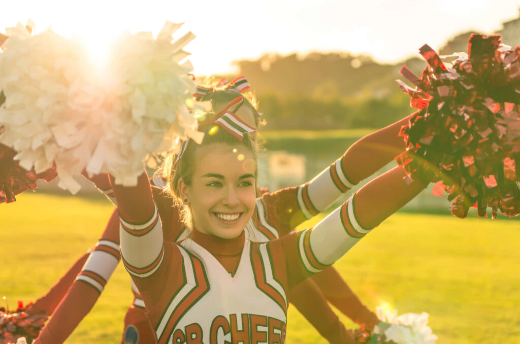 Vibrant Cheerleader Wallpaper: Outdoor Energy & Colorful Uniforms