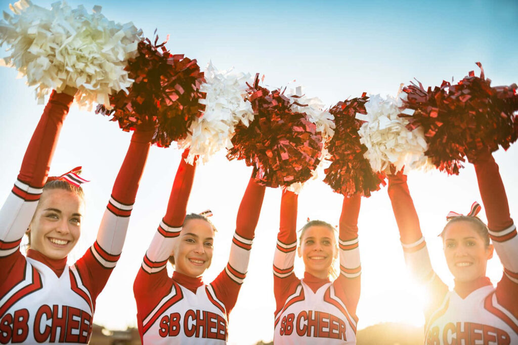 Vibrant Cheerleaders in Red & White: Energetic Stadium Wallpaper