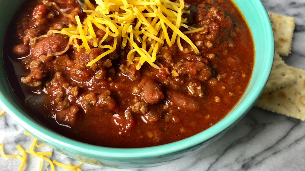 Vibrant Cheesy Chili Con Carne Wallpaper with Crackers & Cheddar