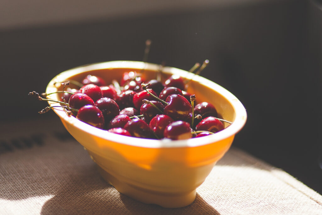 Vibrant Wallpaper: Yellow Bowl of Fresh Cherries in Natural Light