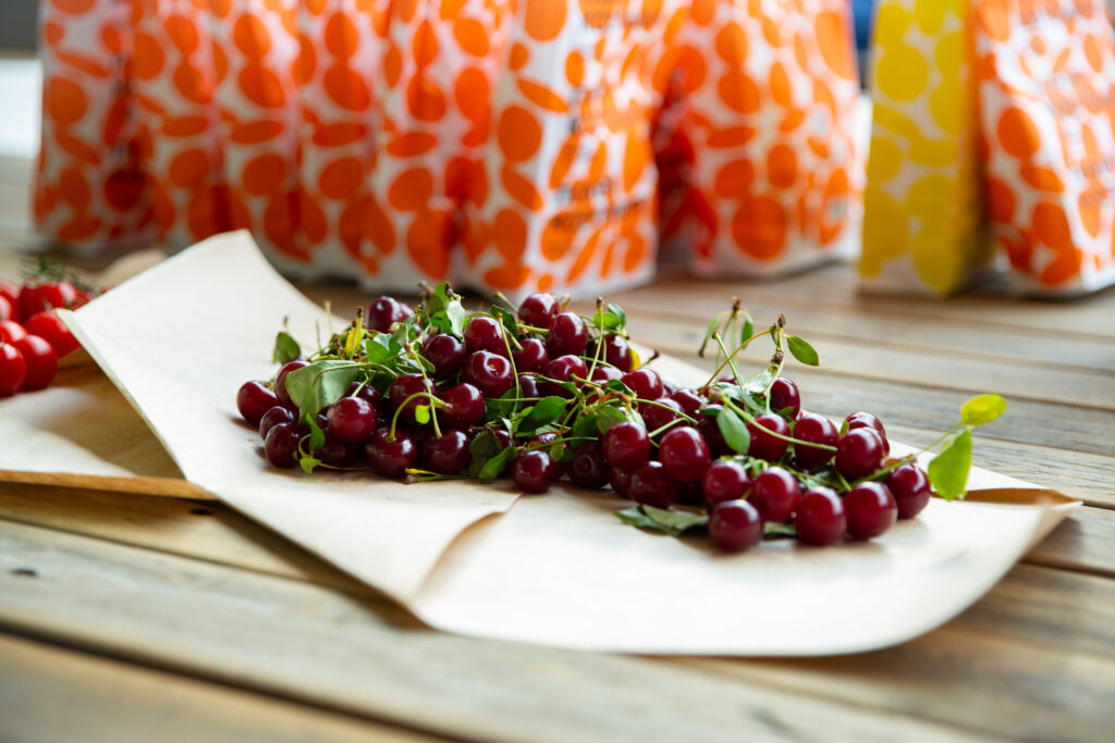 Fresh Cherries Macro Wallpaper: Rustic Table & Blurred Background