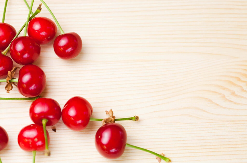 Fresh Red Cherry Wallpaper on Light Wood: Natural Food Aesthetic