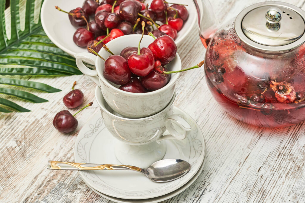 Vibrant Cherry Wallpaper: Teacups & Tea on Rustic Wood Background