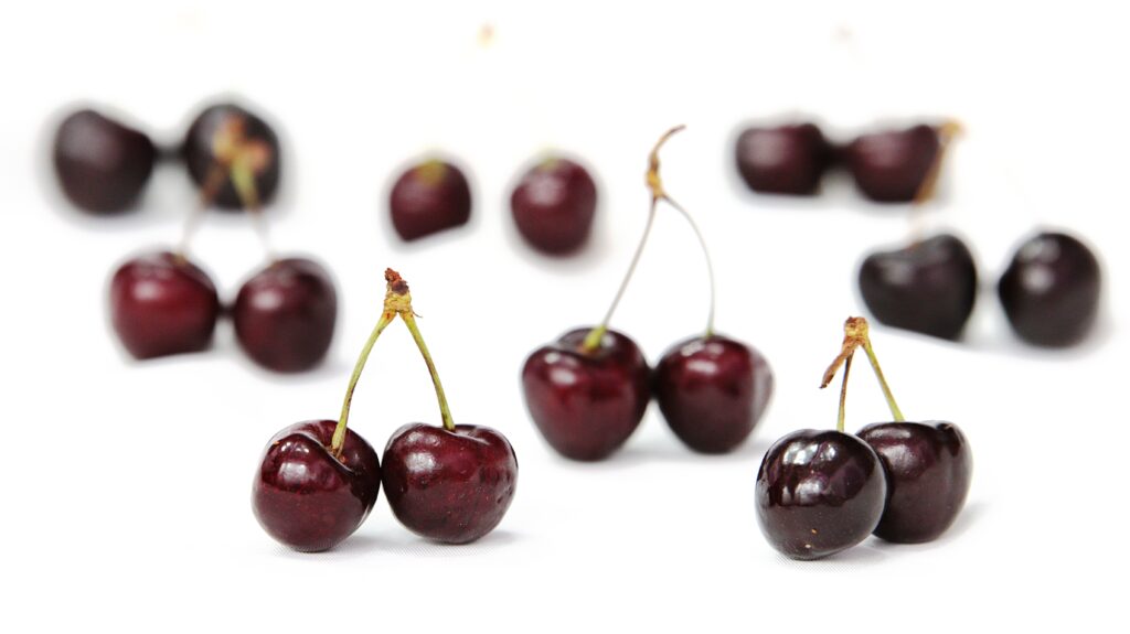 Fresh Cherry Wallpaper: Glossy Cherries on Bright White Background
