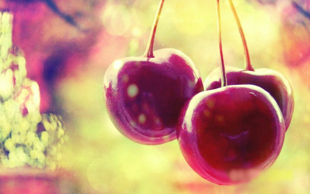 Vibrant Cherry Wallpaper: Glossy Cherries & Colorful Bokeh Background