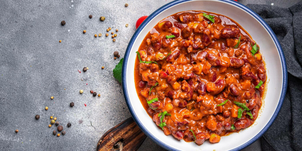 Spicy Chili Con Carne Wallpaper: Vibrant Bowl with Fresh Herbs