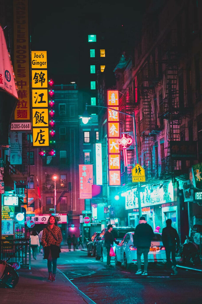Vibrant Chinatown street at night with colorful neon signs and bustling urban nightlife scene Wallpaper